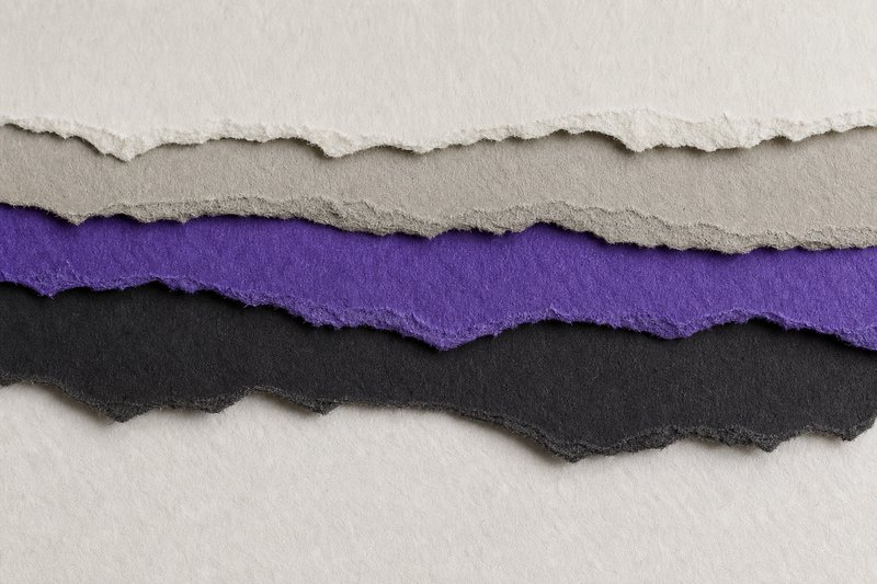A texture study of five torn paper edges layered in overlapping bands, deckled and fibrous, the middle band violet.