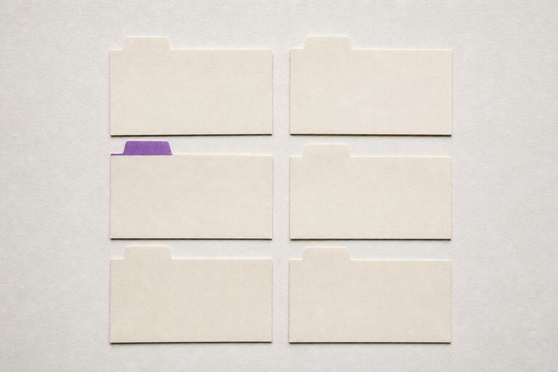 Six blank filing cards laid in a grid, each with a paper index tab, one tab violet.